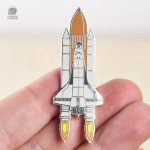 Élégant pin's sur la thématique de l'astronomie et des navettes spatiales